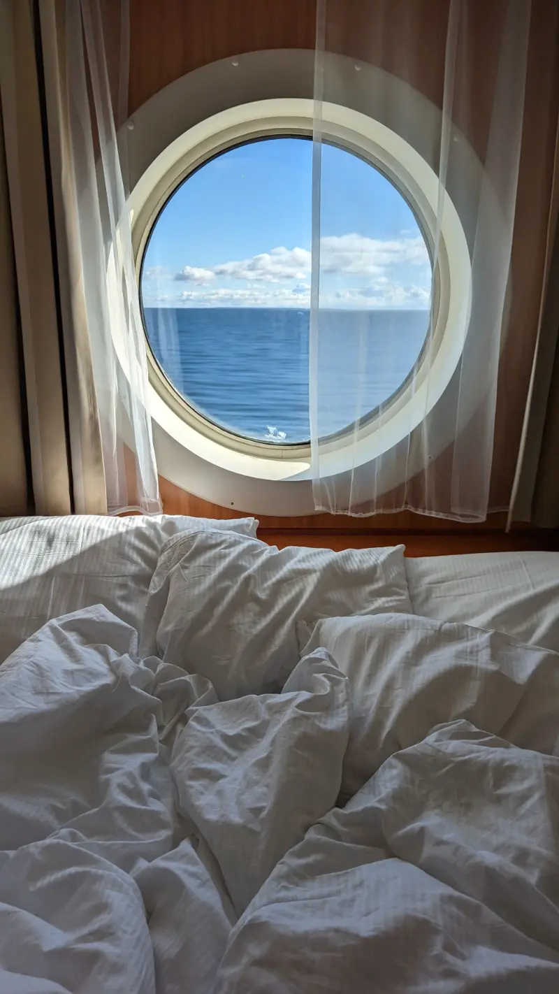 Cruise ship cabin with a made bed and sea view