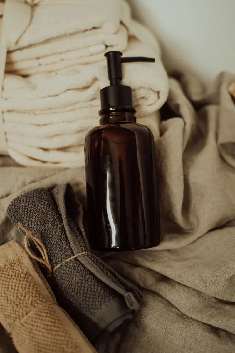 Amber amenity bottle with folded neutral towels